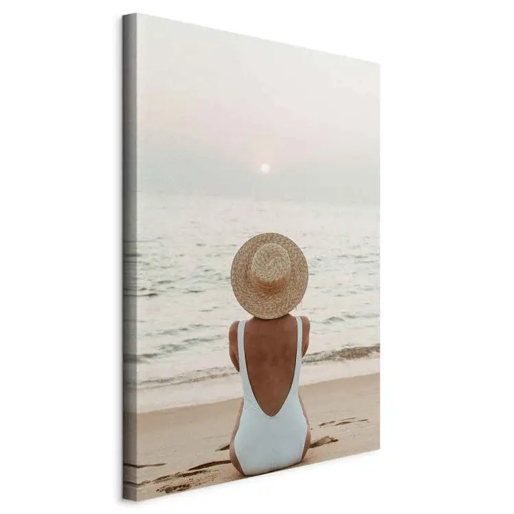 Mulher com chapéu na praia - paisagem marítima com pôr-do-sol